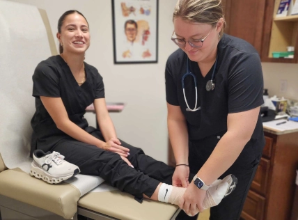 medical assistant students training to treat an ankle injury