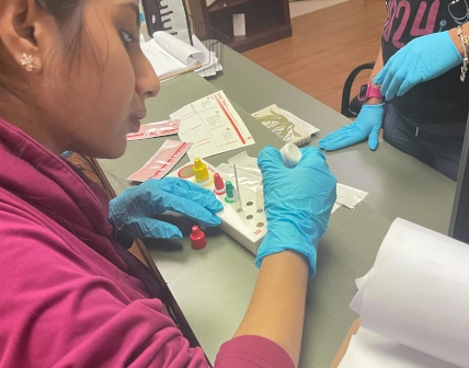 medical assistant student working with blood drawing equipment